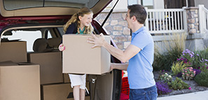 Family unpacking cardboard boxes from car
